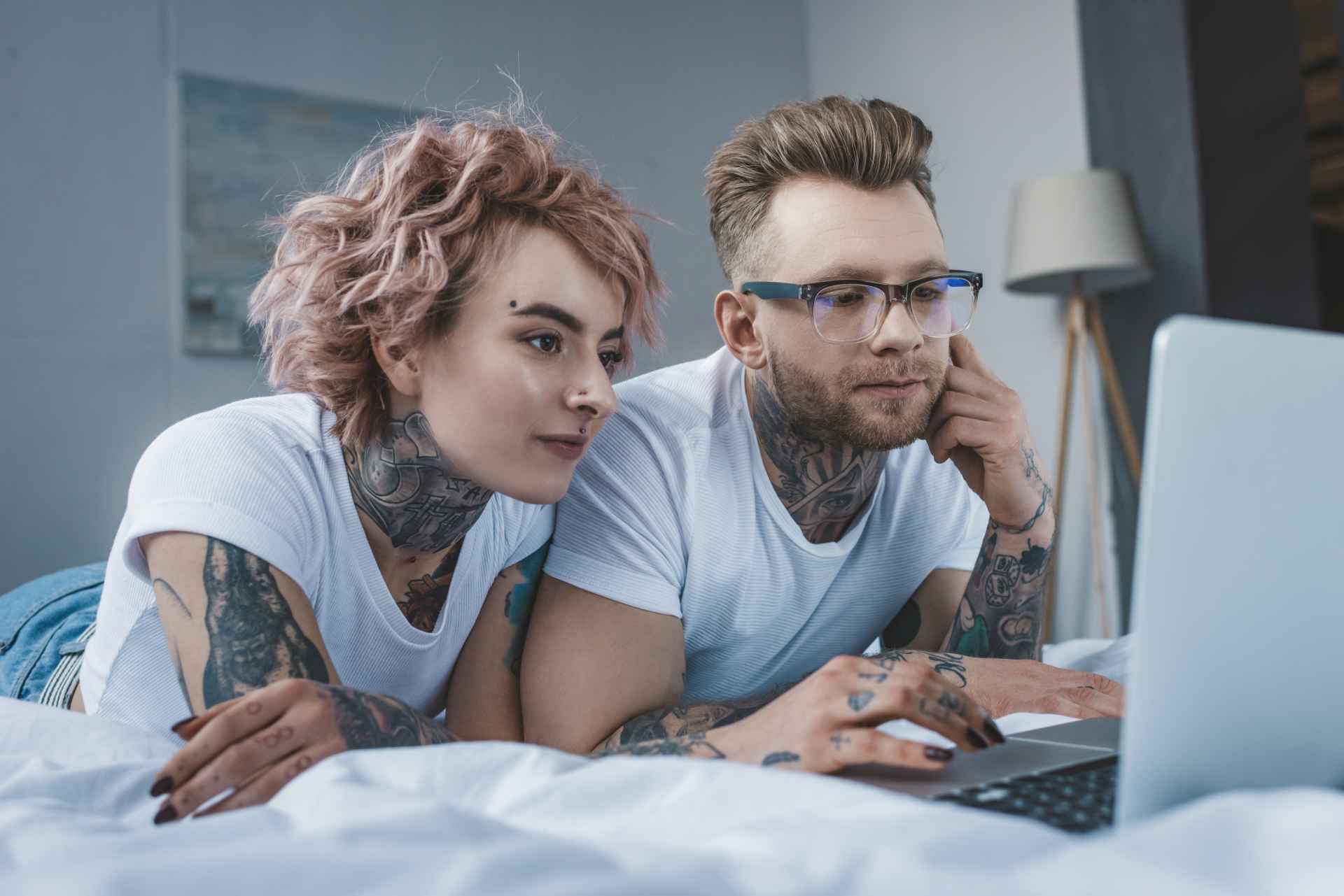 Couple sur un lit navigant sur Internet Couple sur un lit navigant sur Internet