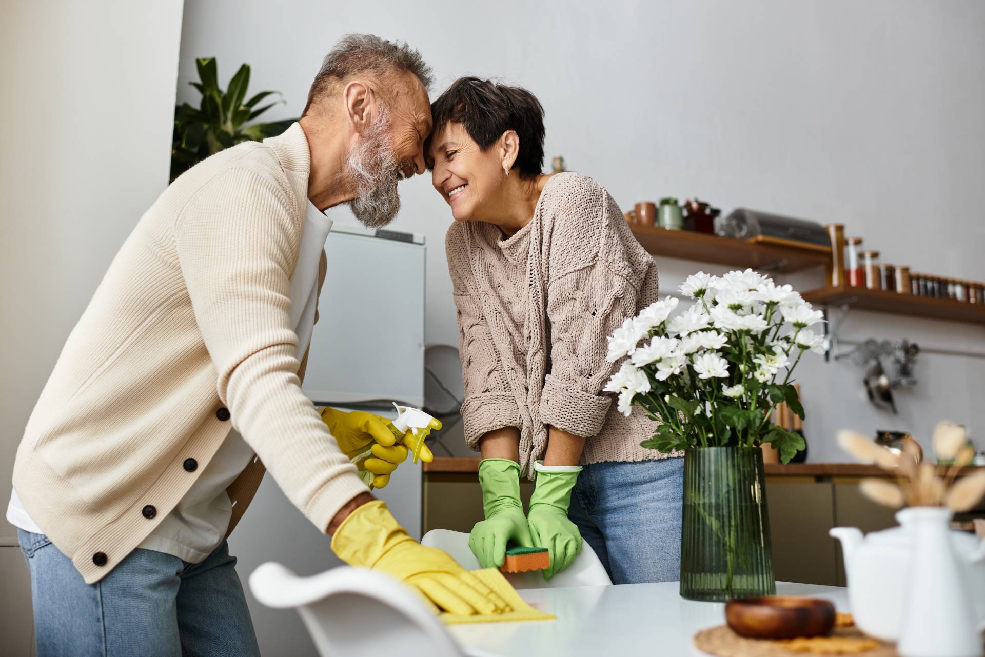 smiling mature couple shares playful banter while cleaning their kitchen smiling mature couple shares playful banter while cleaning their kitchen
