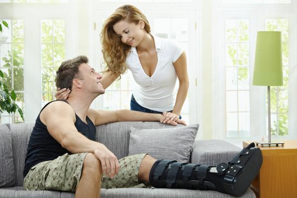 Woman caring for man with broken leg in cast Woman caring for man with broken leg in cast