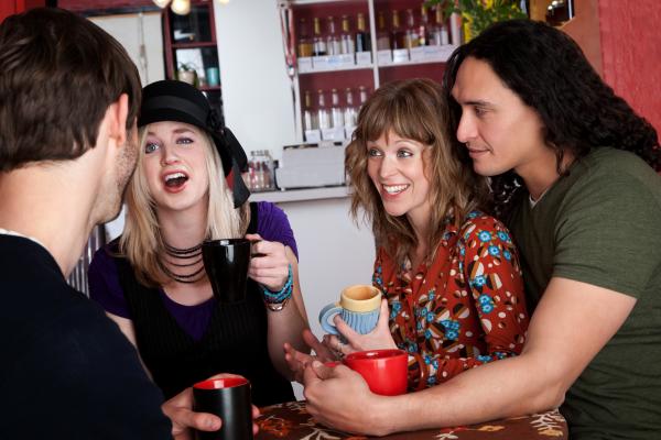 Two couples having a lively conversation at a cafe Two couples having a lively conversation at a cafe