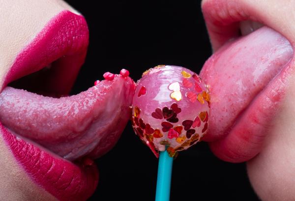 Bisexual women with lollipop suggesting oral sex and kissing Bisexual women with lollipop suggesting oral sex and kissing