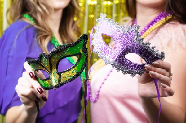 Two swinger women holding New Orleans festival masks and beads Two swinger women holding New Orleans festival masks and beads