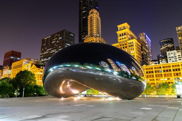 An evening photo of a large reflective silver Chicago art installation called The Bean An evening photo of a large reflective silver Chicago art installation called The Bean