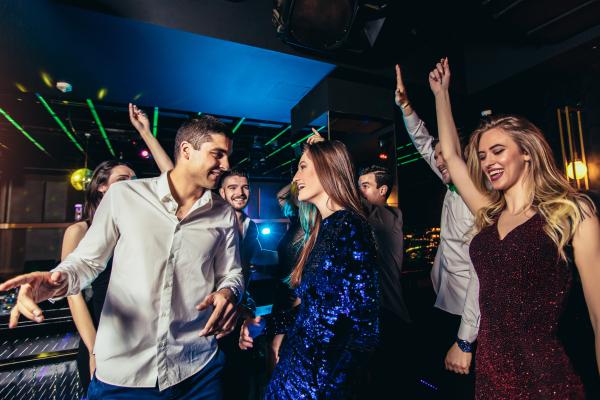a photo of a group of swingers dancing and chatting at a night club party
