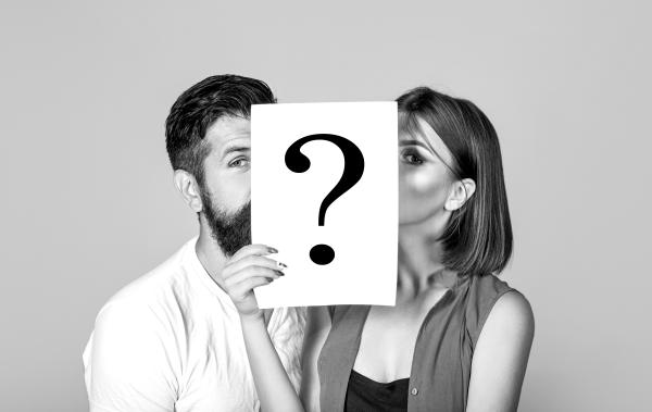a photo of a couple holding a white sheet of paper with a large black question mark a photo of a couple holding a white sheet of paper with a large black question mark