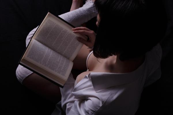 a photo taken from above of a busty woman in white lingerie reading an open book a photo taken from above of a busty woman in white lingerie reading an open book