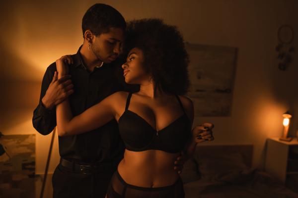 sensual Black couple in a dimly lit bedroom sensual Black couple in a dimly lit bedroom