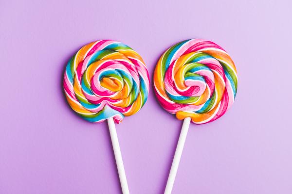 two colorful lollipops on a purple background two colorful lollipops on a purple background