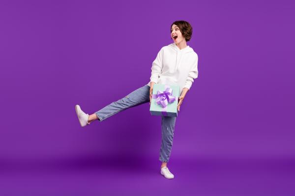 woman over purple background excited about her gift woman over purple background excited about her gift