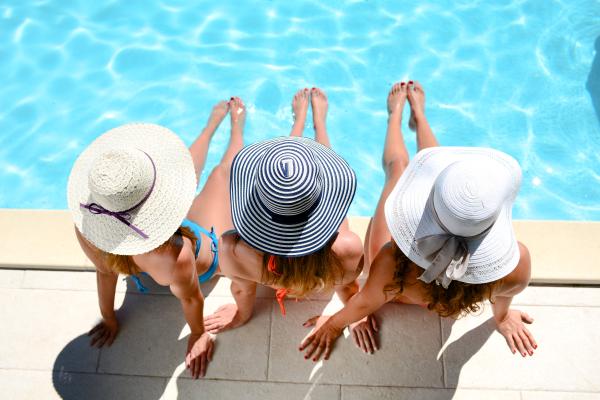 group of women in sun hats by a pool group of women in sun hats by a pool