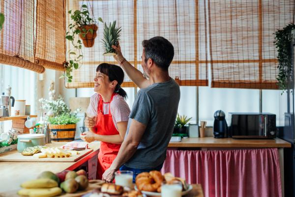 Playful couple in the kitchen with a pineapple Playful couple in the kitchen with a pineapple