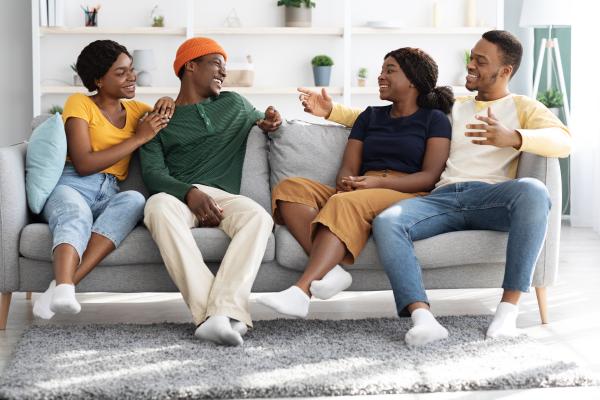 Two cheerful Black couples having a lively conversation on the couch Two cheerful Black couples having a lively conversation on the couch