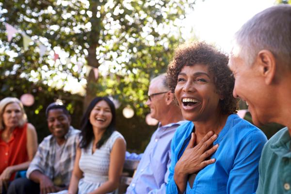 Happy group of people laughing and smiling together in a backyard Happy group of people laughing and smiling together in a backyard