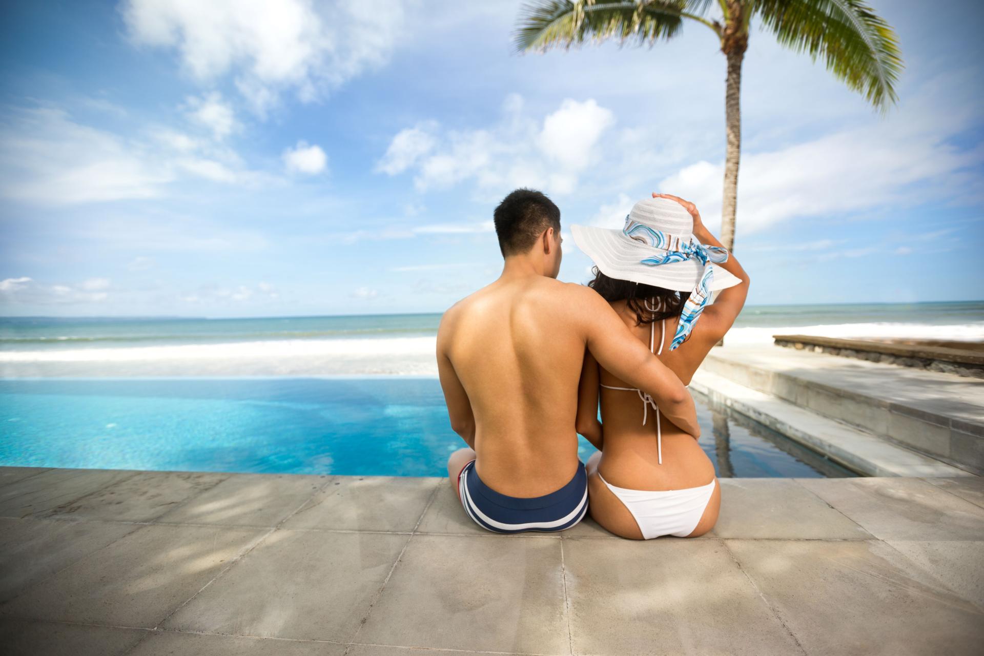 swinger couple in swimwear at the edge of a pool