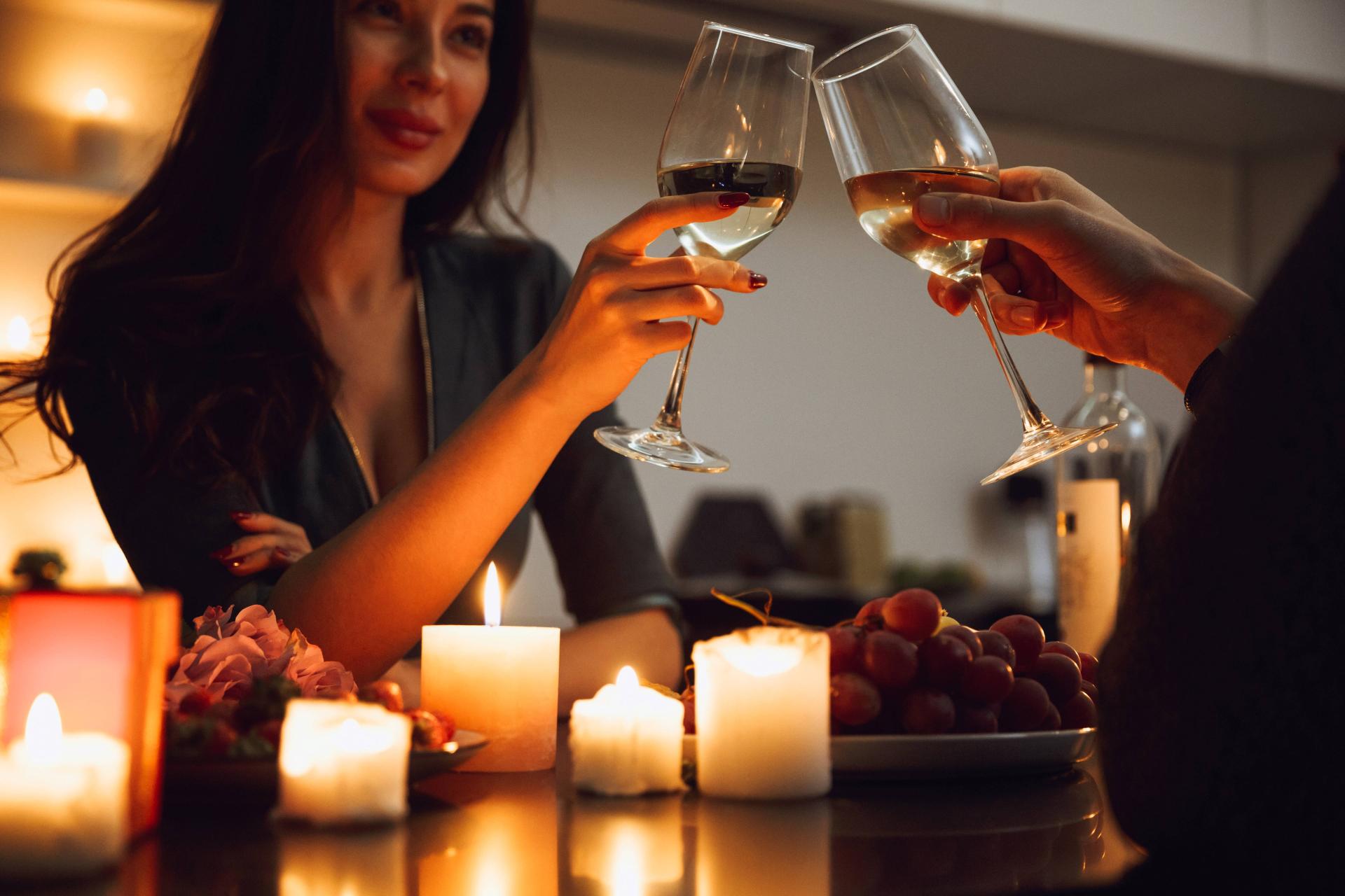 couple clinking wine glasses over an intimate romantic dinner