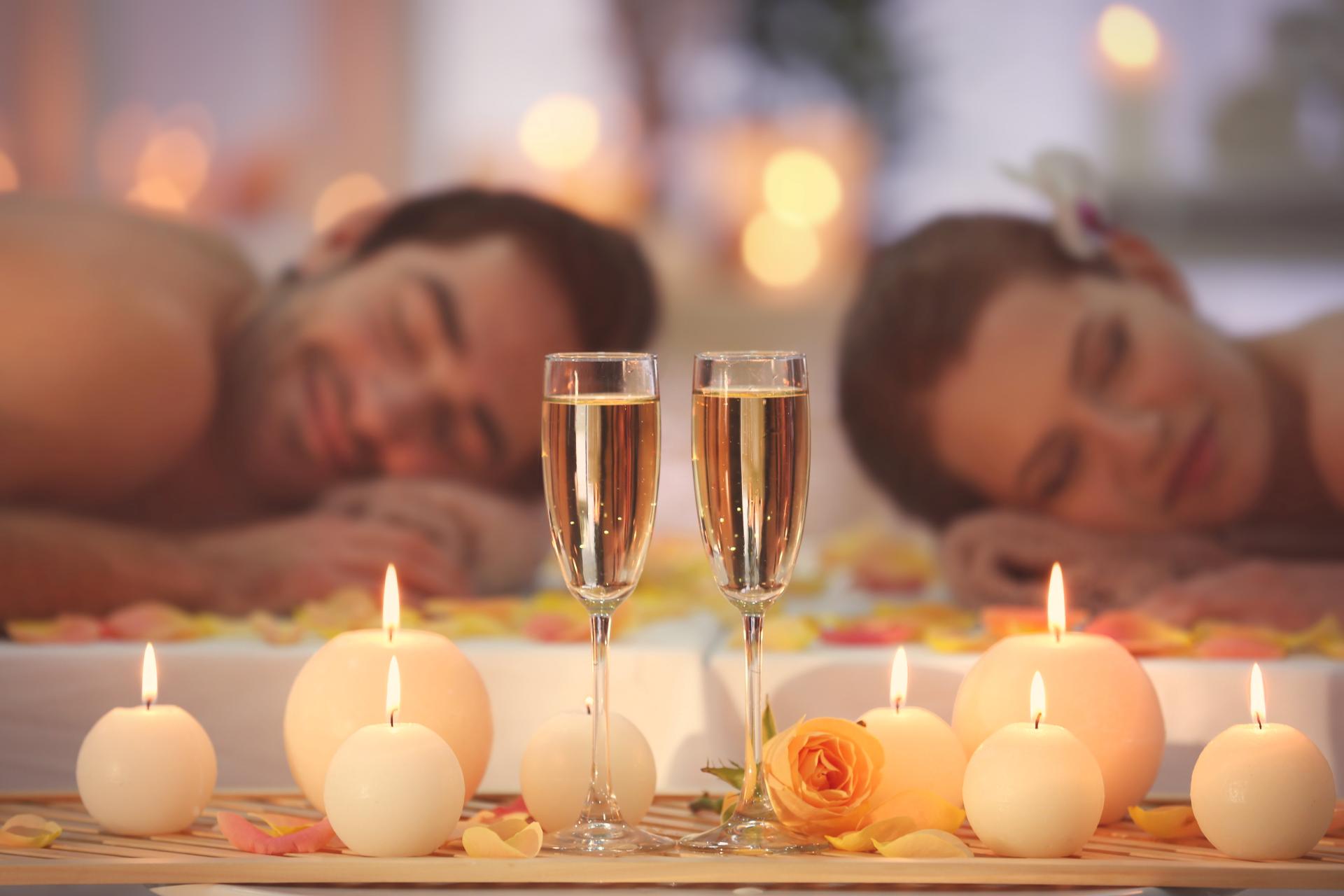 swinger couple enjoying a relaxing spa and champagne by candlelight