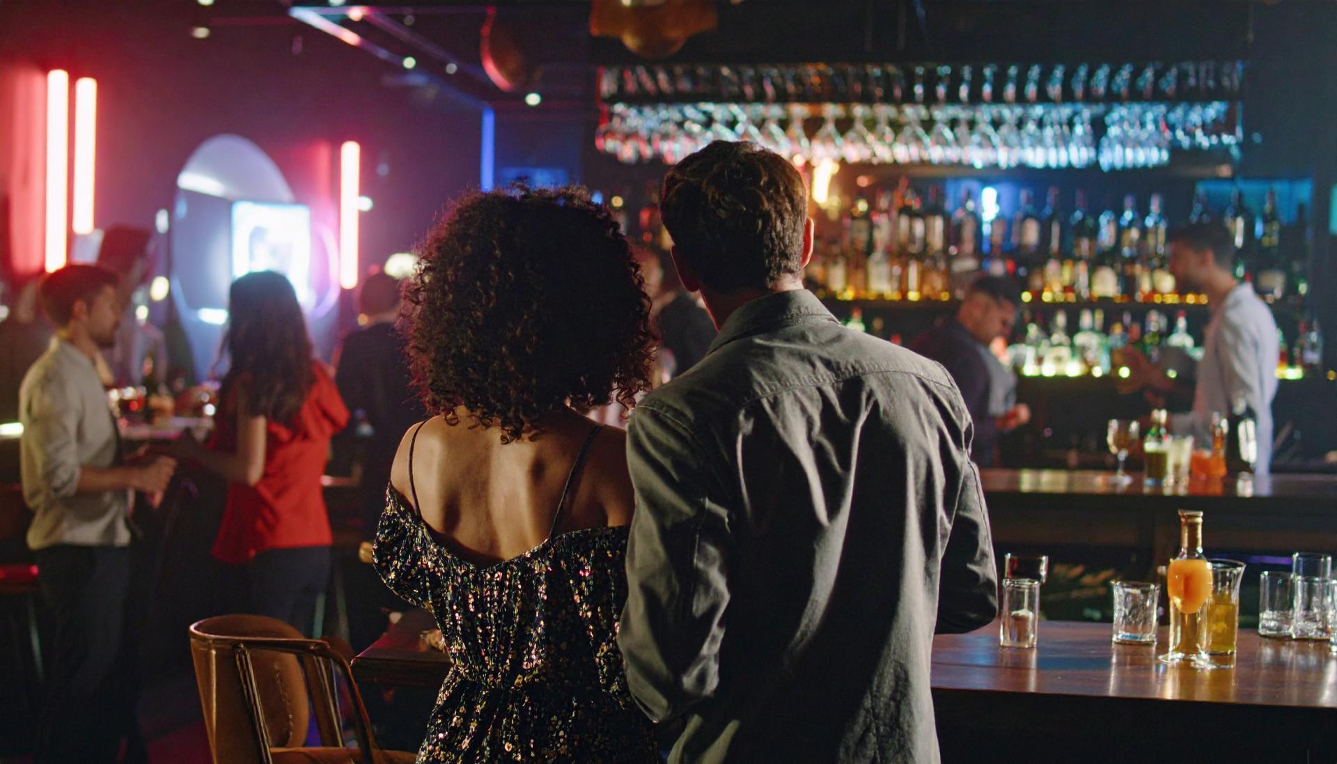 a couple looking at a room of people at a night club a couple looking at a room of people at a night club