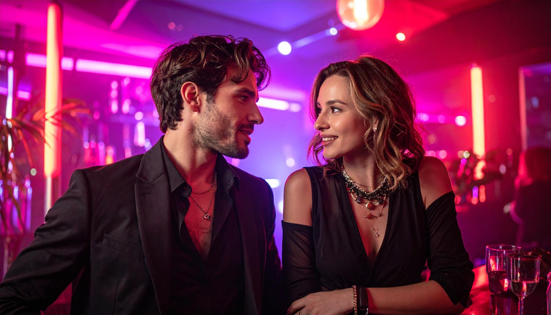 couple wearing black and having conversation at a night club couple wearing black and having conversation at a night club