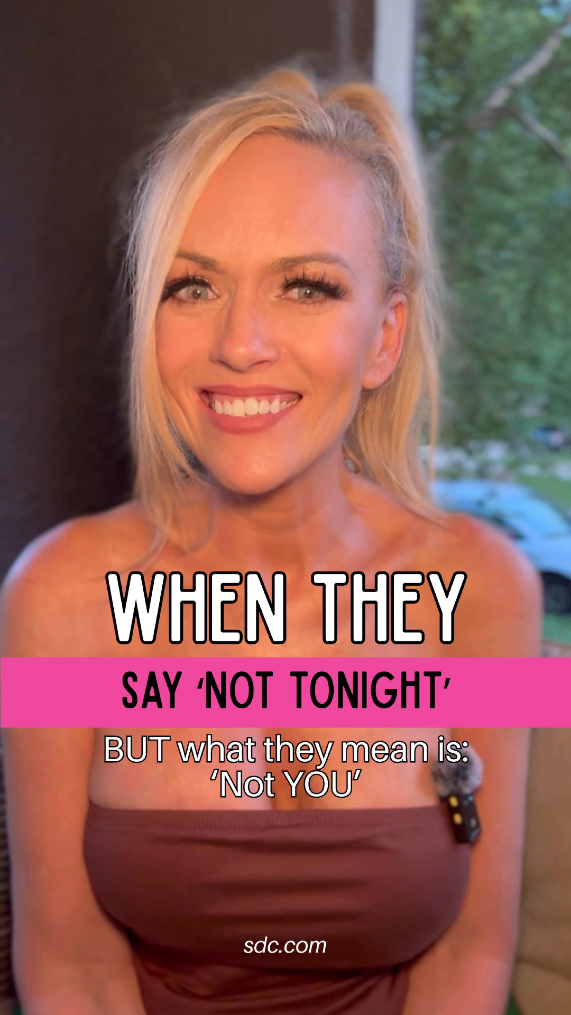 Smiling blonde woman wearing a strapless brown top with text overlay describing the video contents