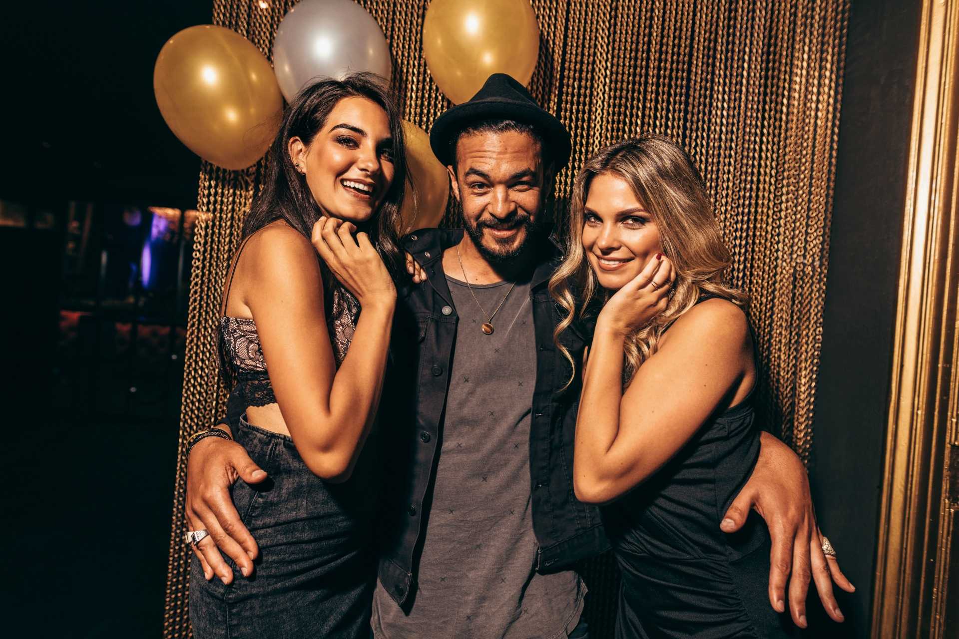 smiling man between two women at a party