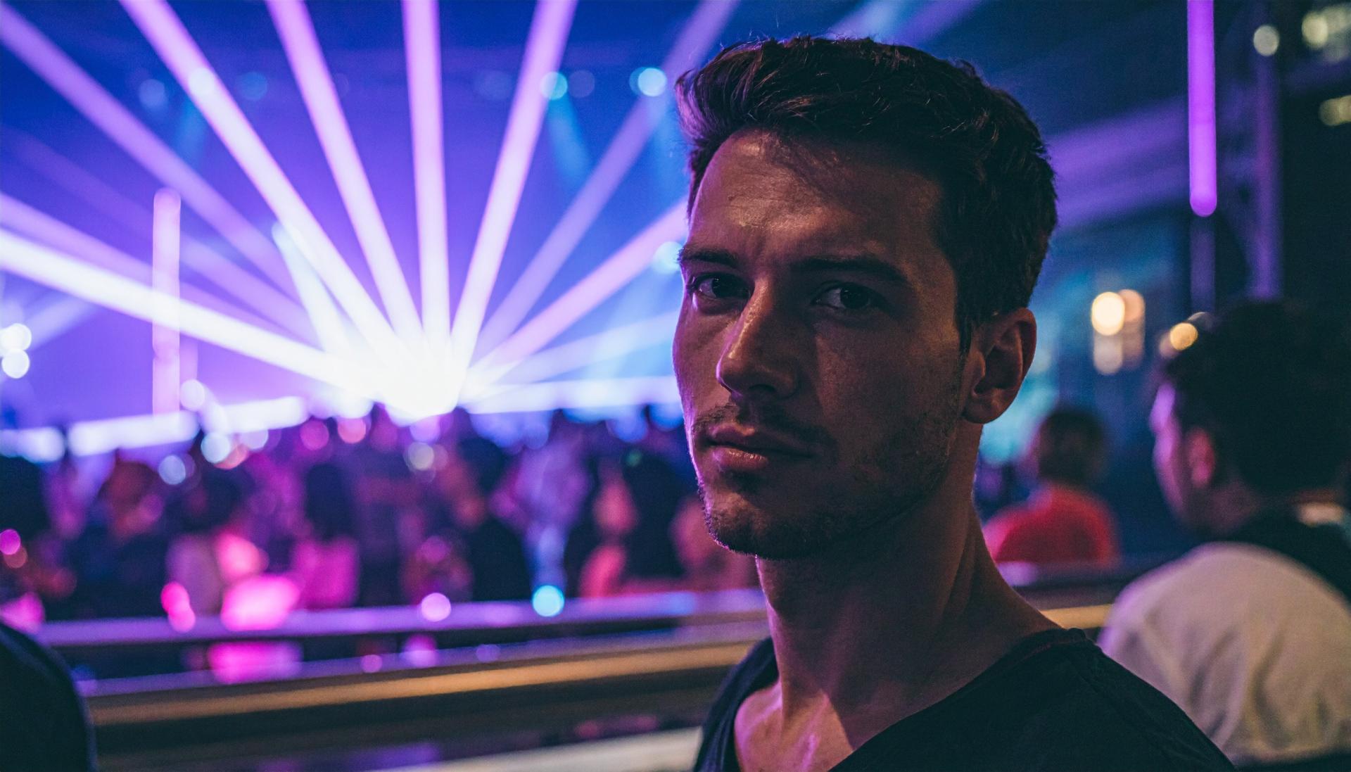 man at a party at a night club with purple and blue light