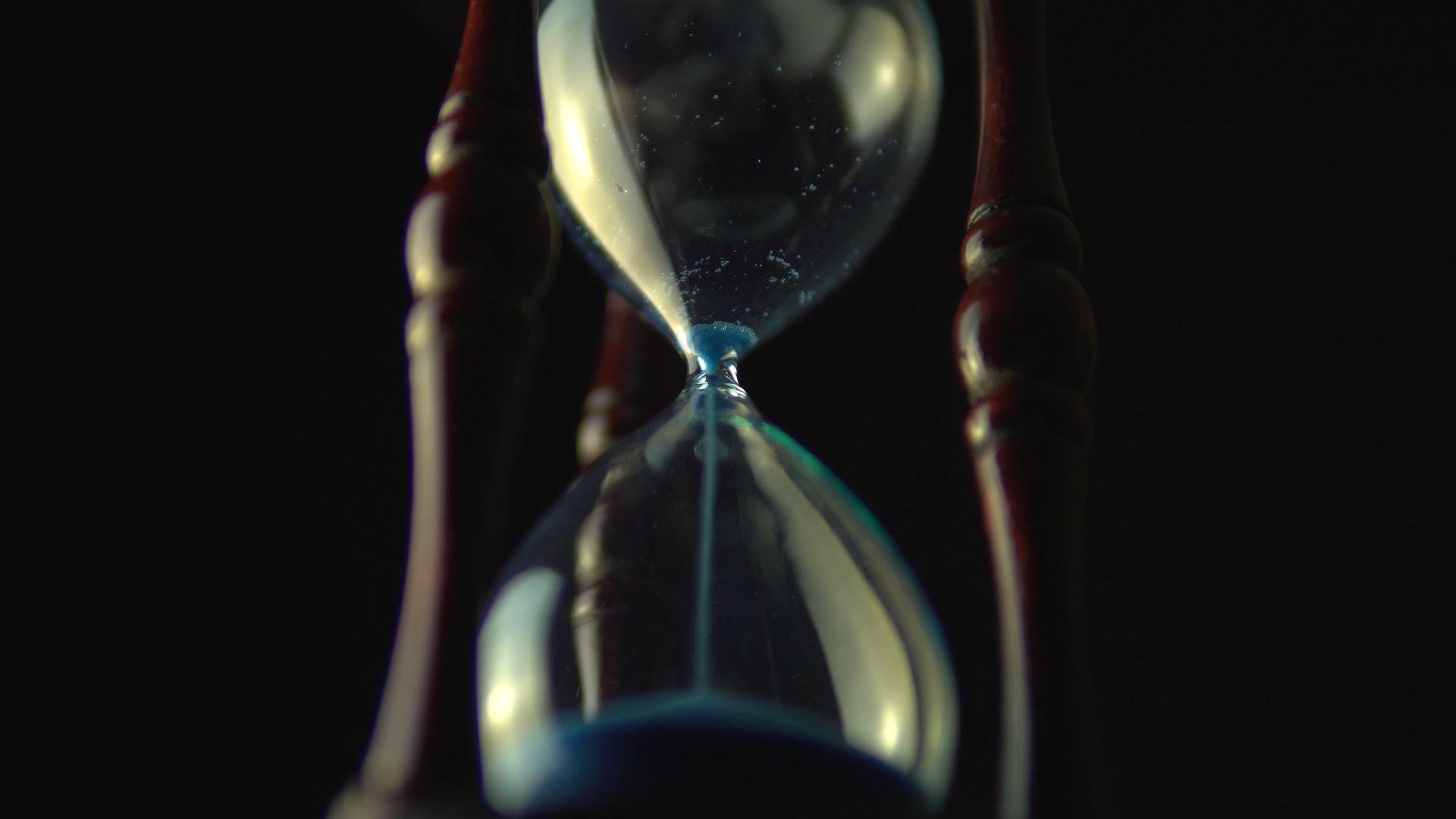view from the base of an hourglass with blue sand running out of the top half