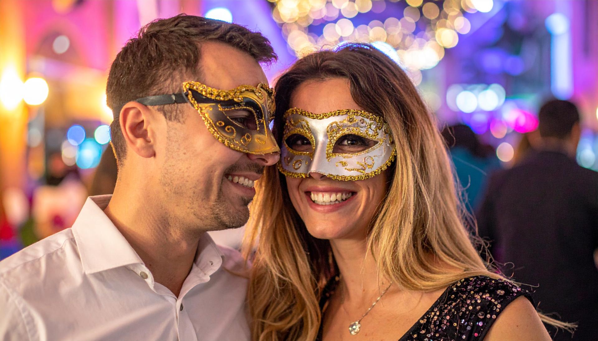 couple at a party wearing venetian masks