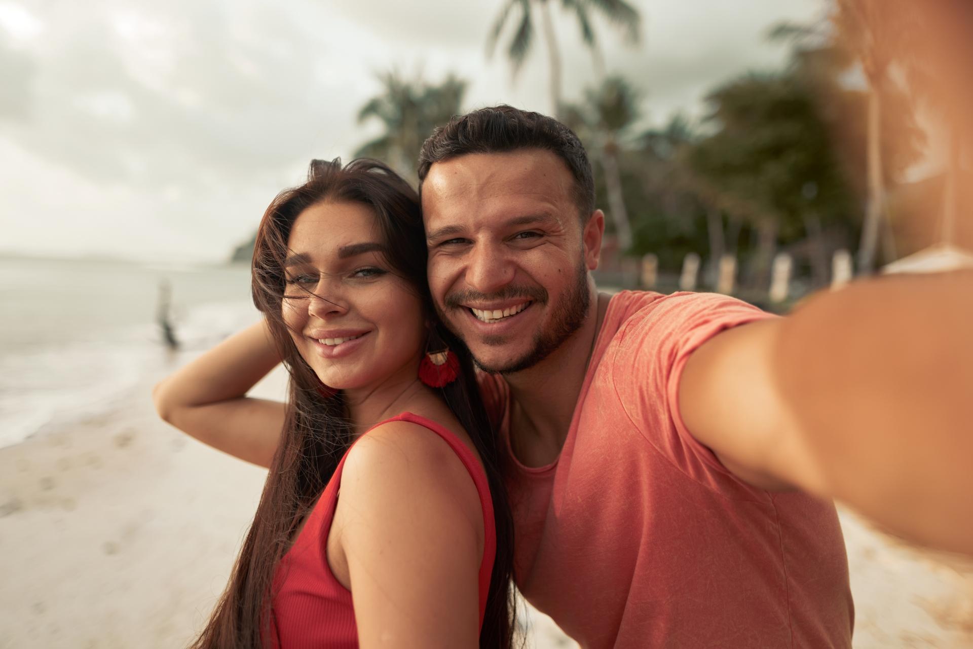 happy couple taking a selfie on a beach