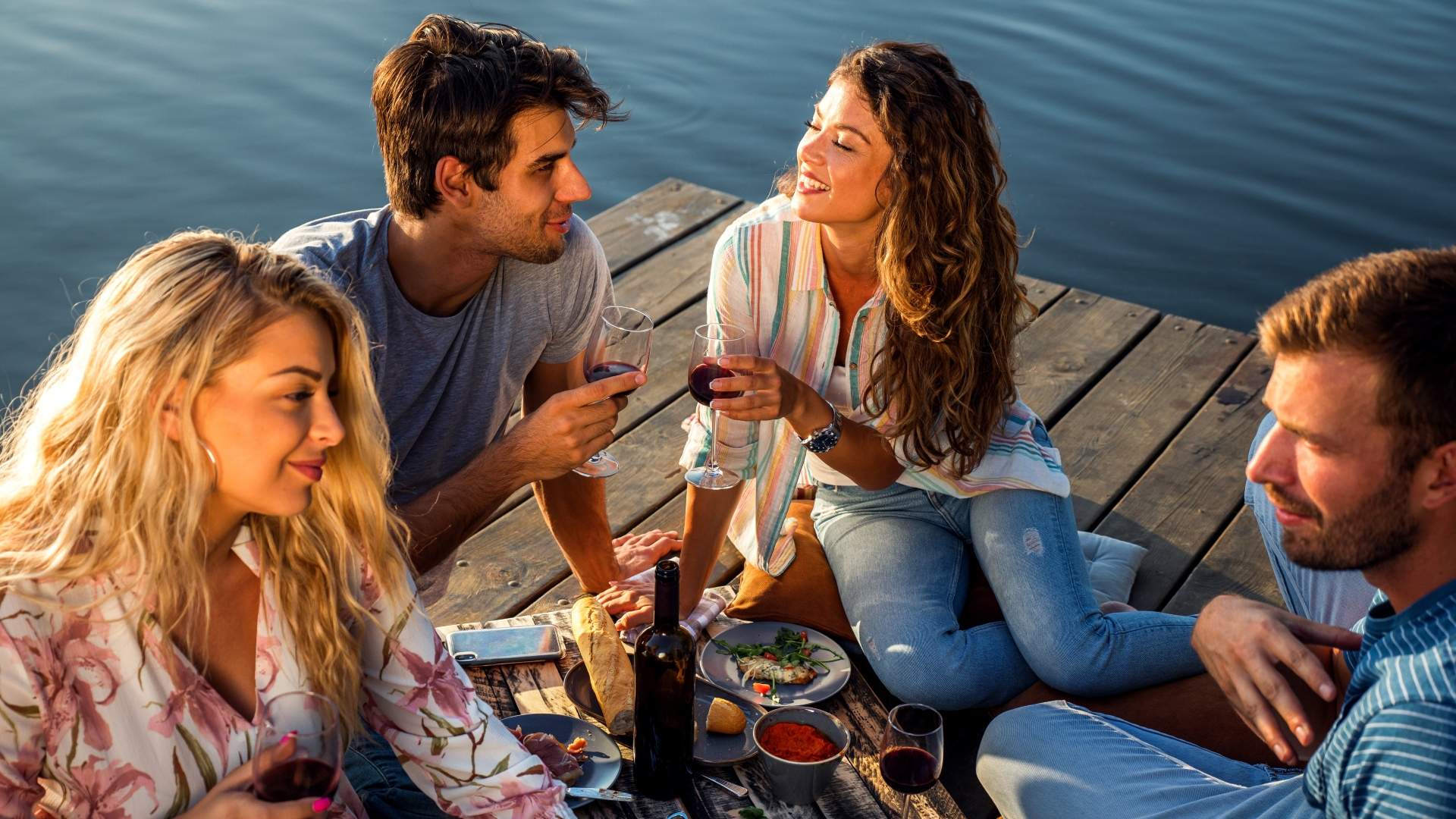 two couples enjoying a double date dinner on a pier