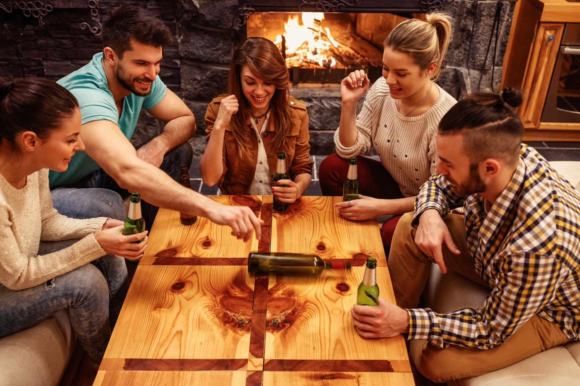 a group of men and women playing spin the bottles and drinking