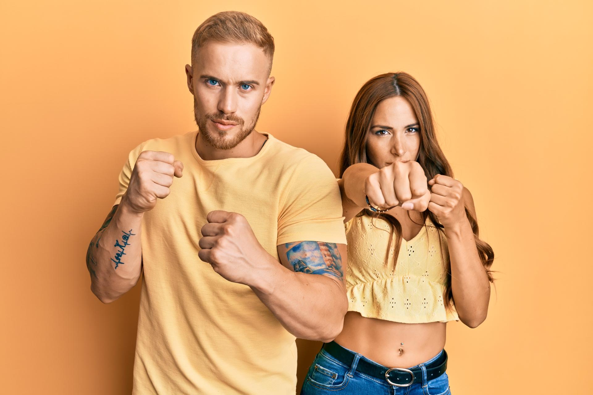 a man and woman dressed in yellow making tough and resilient gestures