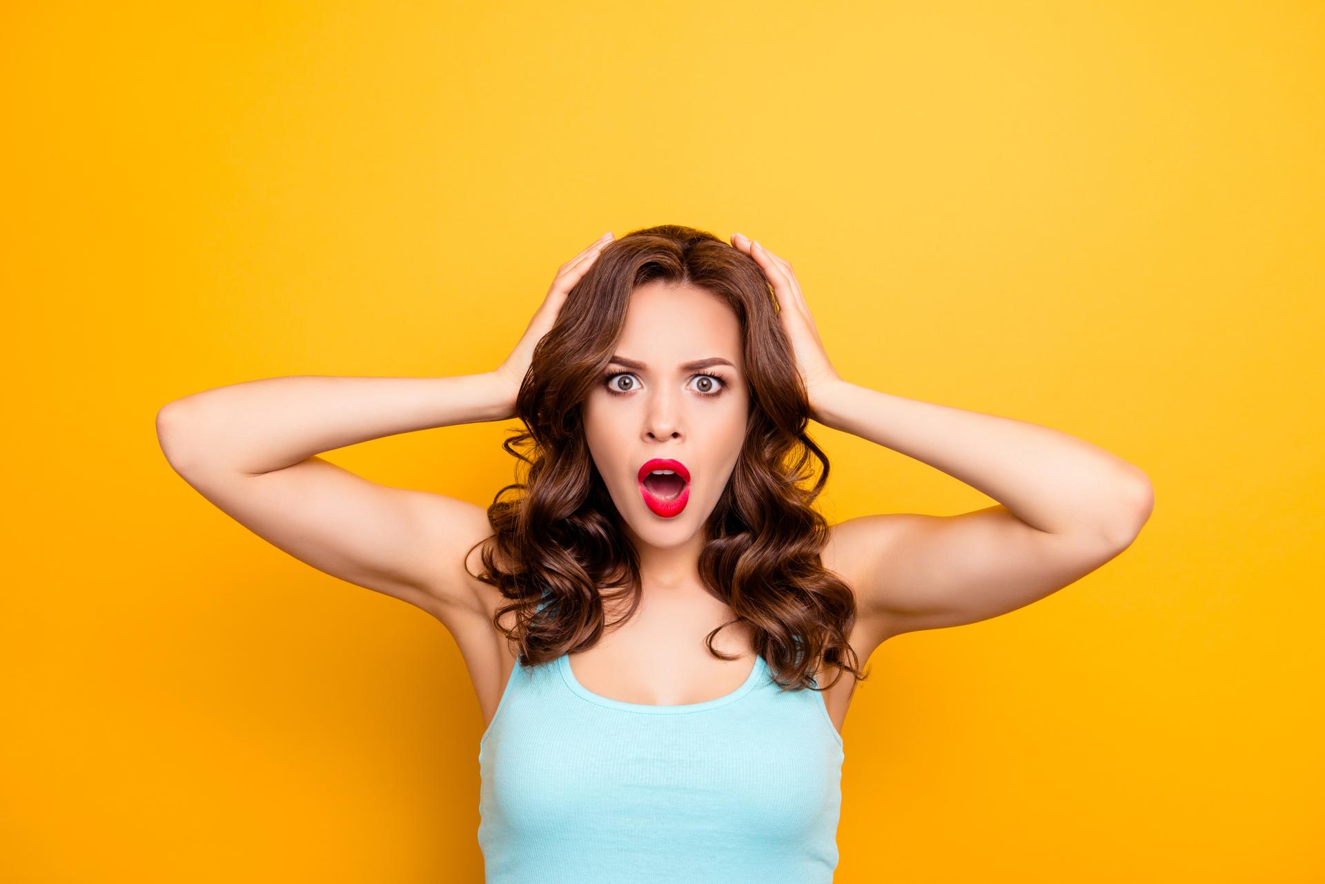 a woman wearing a light blue shirt with a surprised look on her face