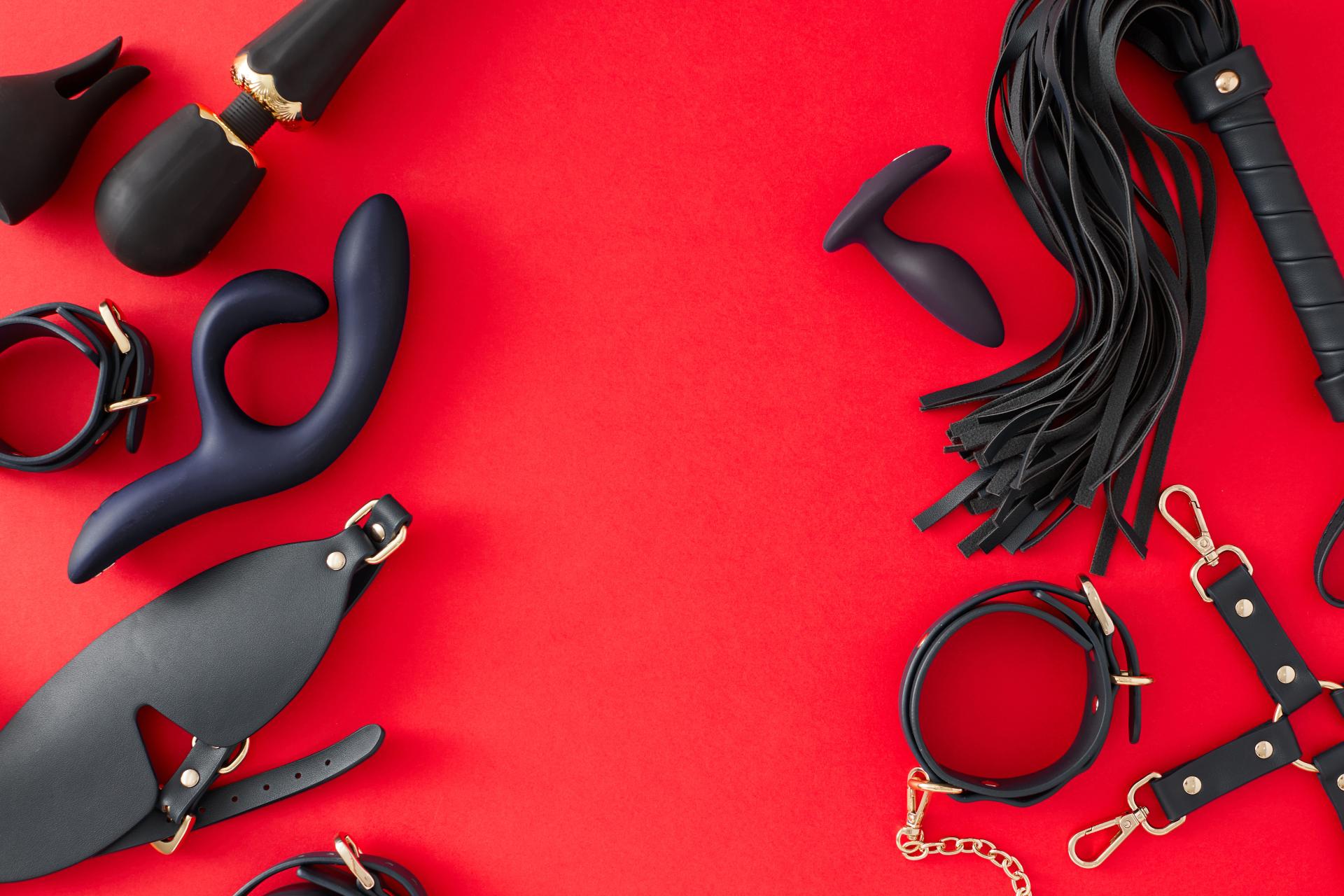 sex toys laid against a red background