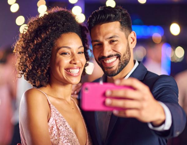 couple taking selfies in a night club with magenta smartphone couple taking selfies in a night club with magenta smartphone