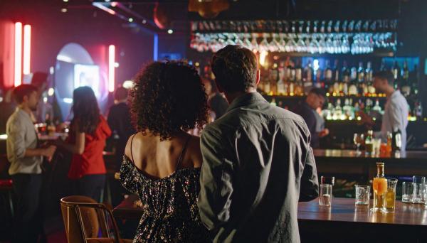 a couple looking at a room of people at a night club a couple looking at a room of people at a night club