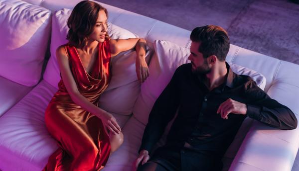 couple chatting on a white leather sofa at a night club