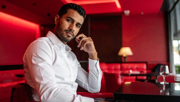 confident man sitting at a luxury club with a red theme