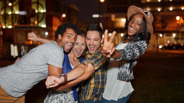 playful group of people on a double date on the downtown sidewalk at night