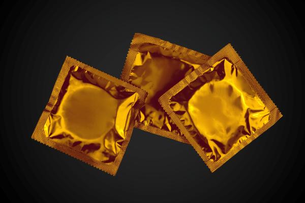 Gold condoms over a black background
