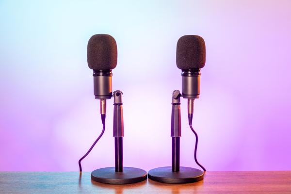 two podcast microphones over a purple background
