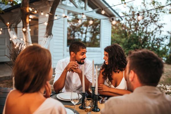 giddy couple having dinner with friends outdoors