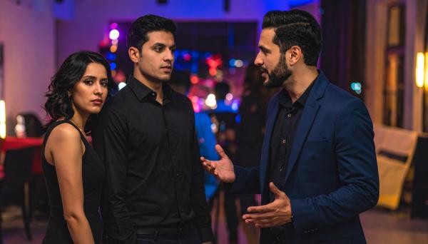 couple listening to a talkative man at a party