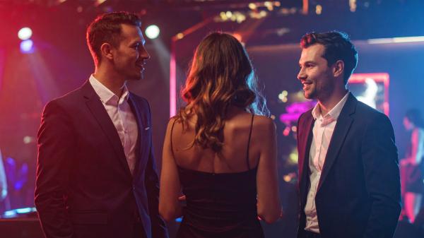 three people chatting at a nightclub
