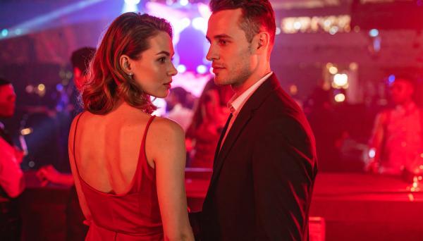 couple looking at the crowd at a nightclub with red lighting