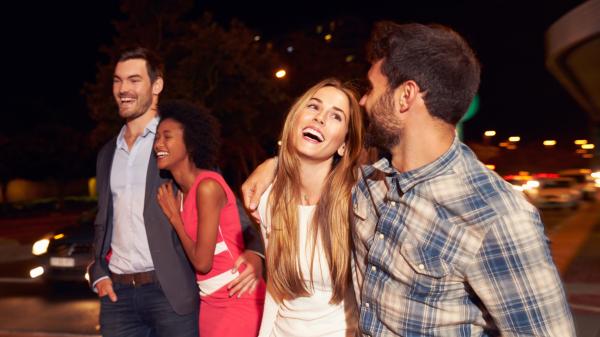 two flirtatious couples walking in the city at night