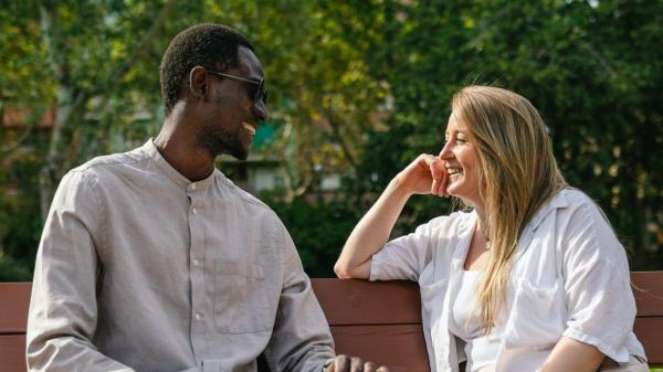 couple having a conversation on a park bench