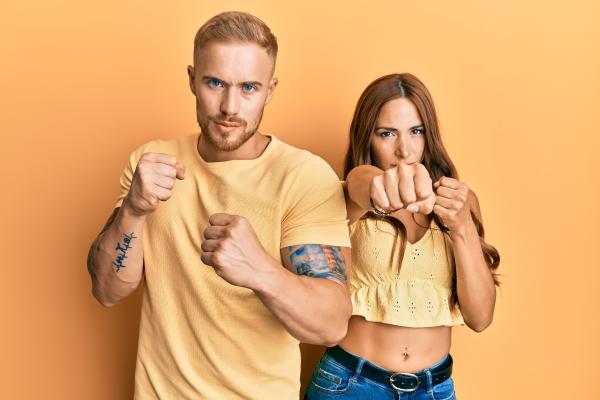 a man and woman dressed in yellow making tough and resilient gestures