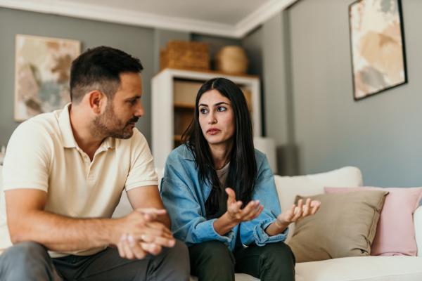 a man and a woman sitting on a couch having a serious discussion