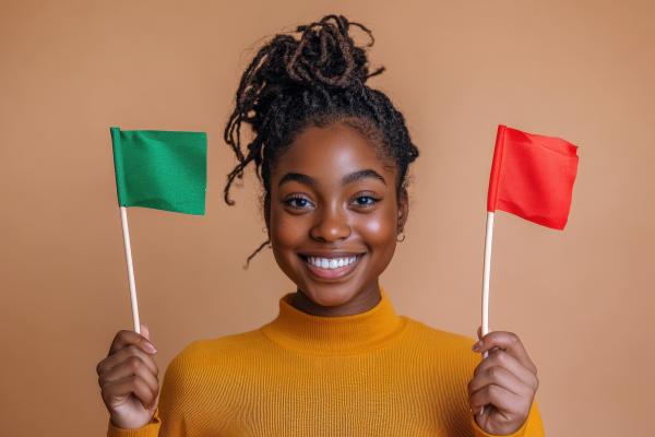 a woman wearing a yellow shirt holding a red and green flag