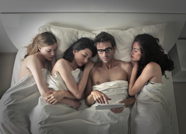 a man holding two women close to him